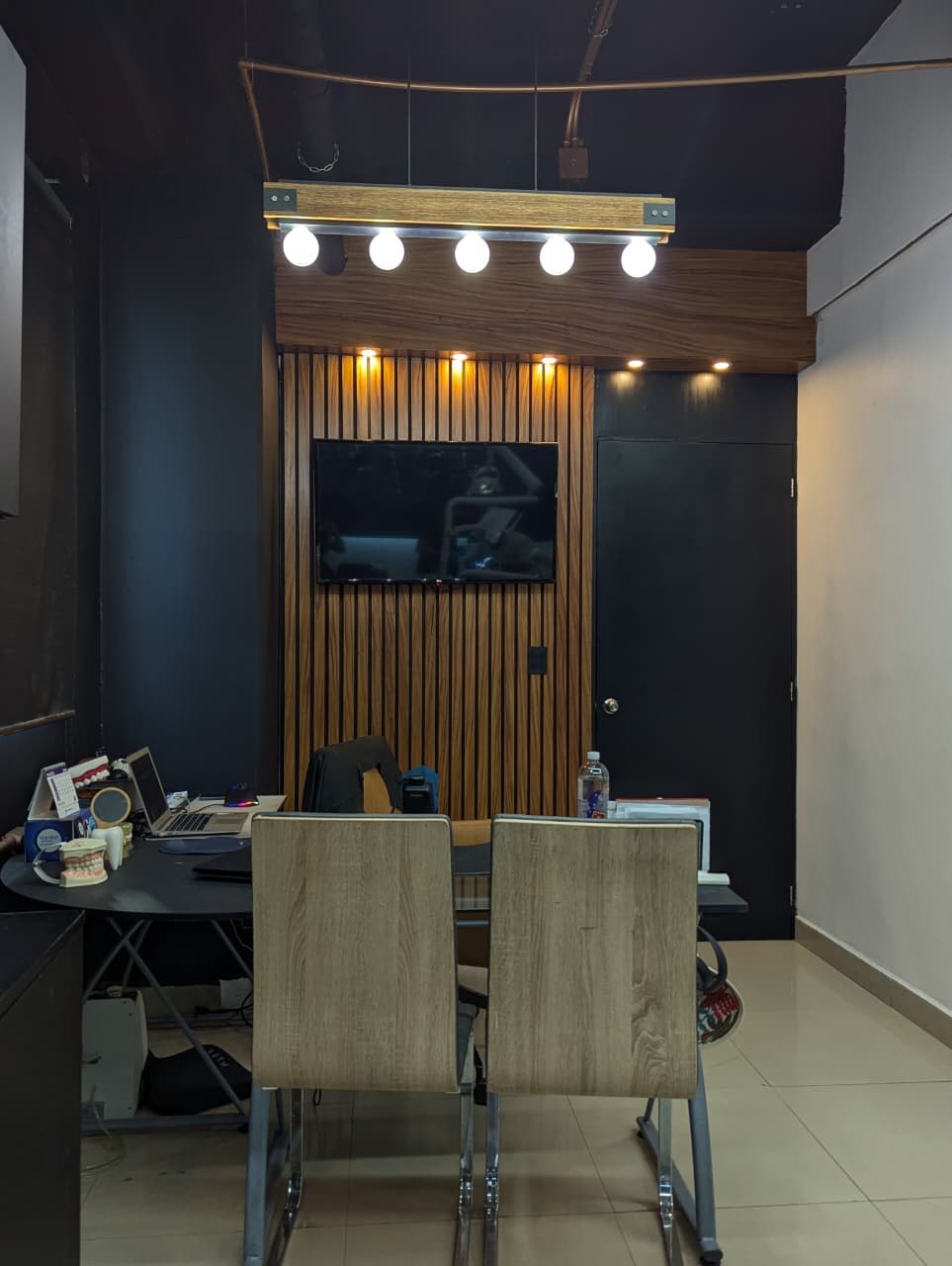 Sala de consulta con pared de madera, pantalla y escritorio
